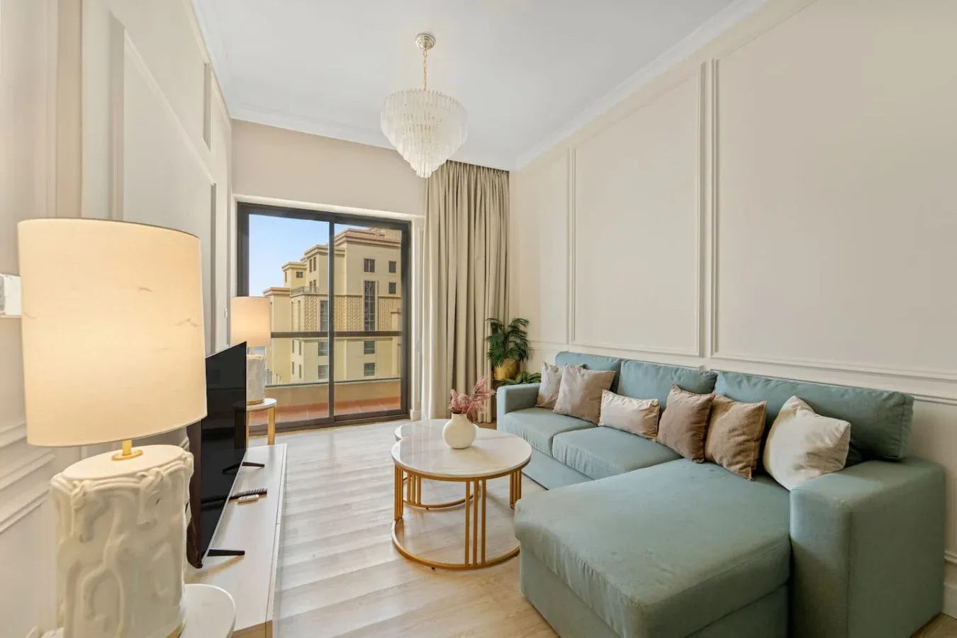 Una sala de estar con asientos, una mesa de centro y una ventana con vista a edificios cercanos.