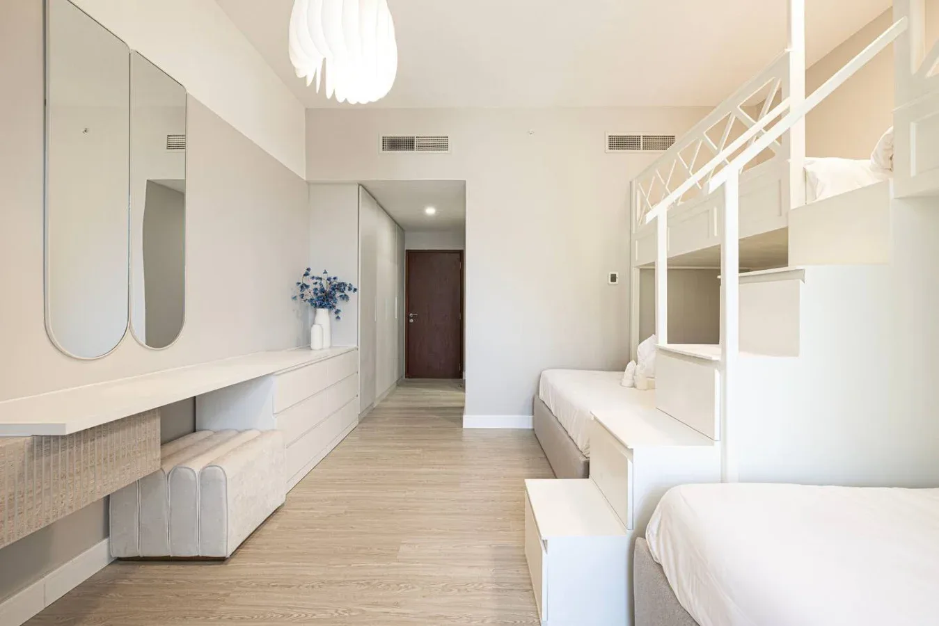 Un dormitorio luminoso con literas y asientos integrados.