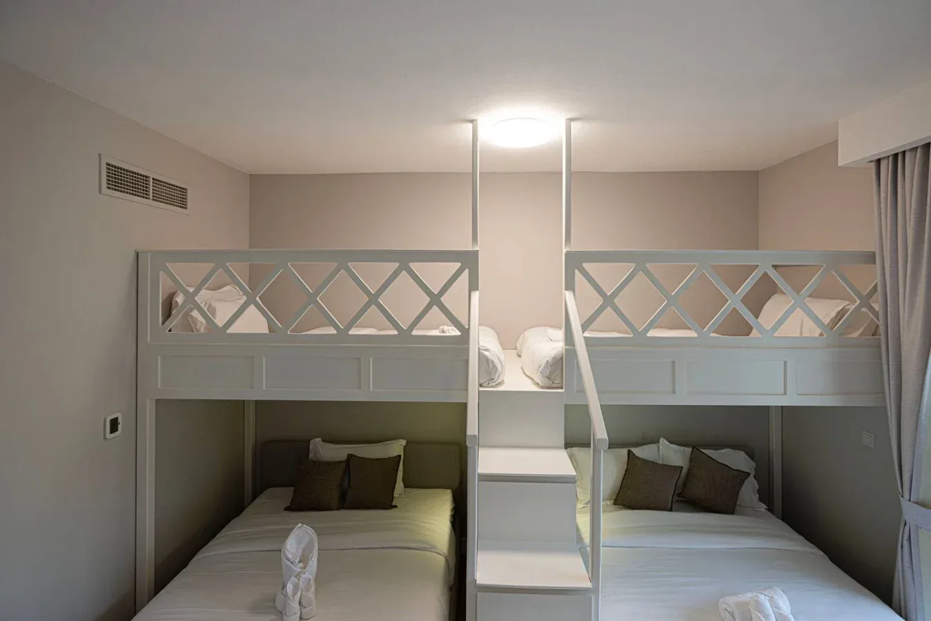 Dormitorio con dos literas y una escalera estrecha entre ellas.