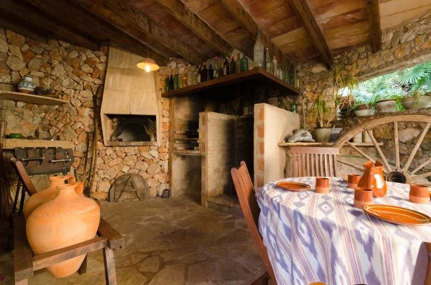 Un comedor rústico con una chimenea de piedra y una mesa puesta con platos.