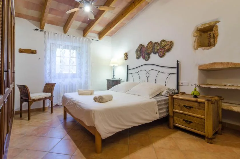 Un dormitorio con una cama, muebles de madera y una ventana con cortinas.