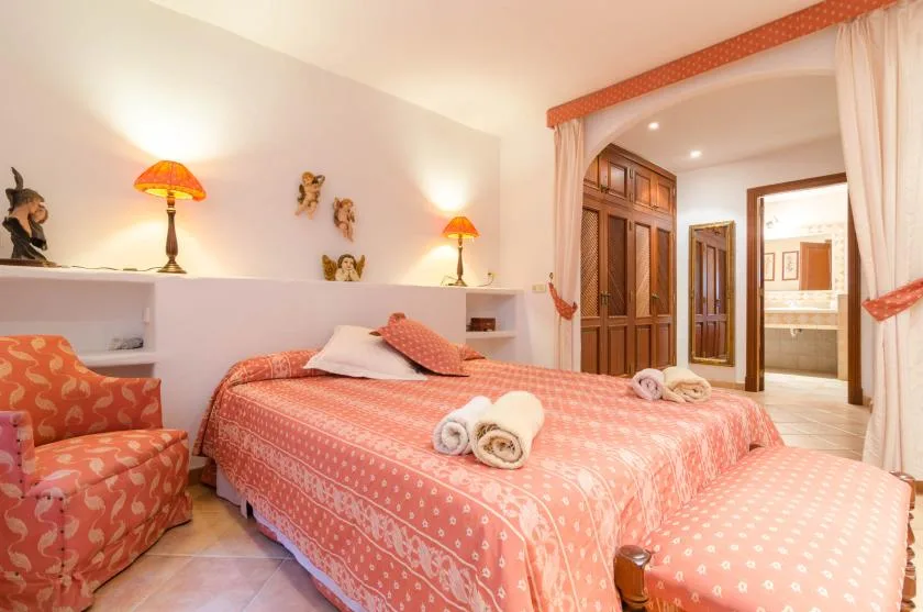 Un dormitorio con una cama estampada en coral y asientos tapizados a juego.