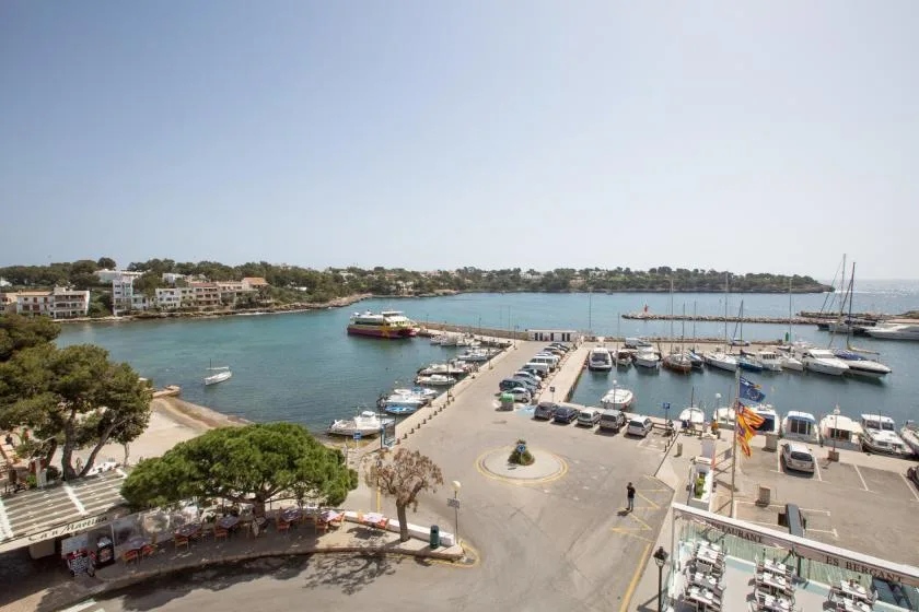 Un puerto deportivo con barcos amarrados junto a un pueblo costero.