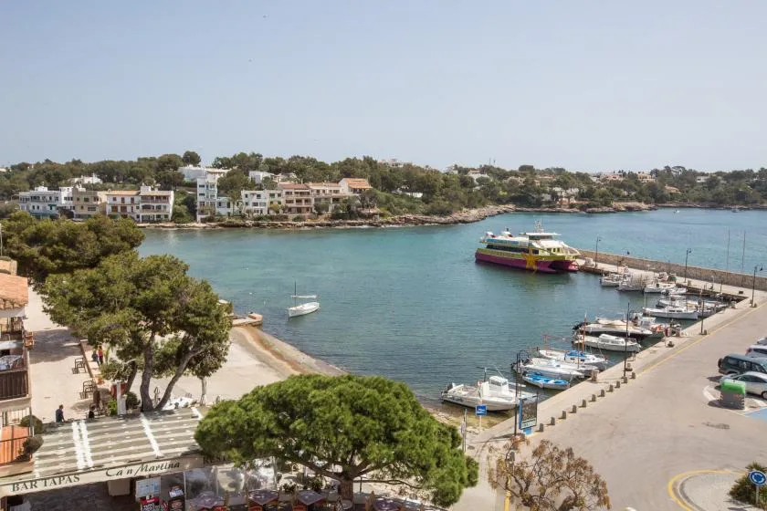 Un puerto costero con barcos amarrados junto a un paseo marítimo.