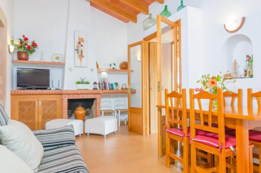 Un salón-comedor luminoso con chimenea y mesa de comedor de madera.
