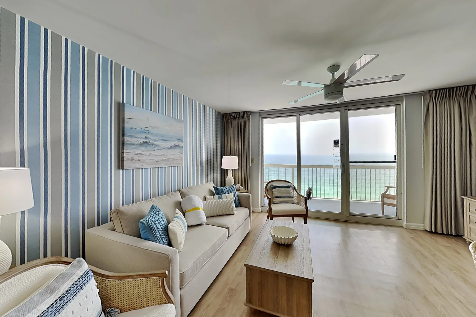 A living room with seating and large windows overlooking the water.