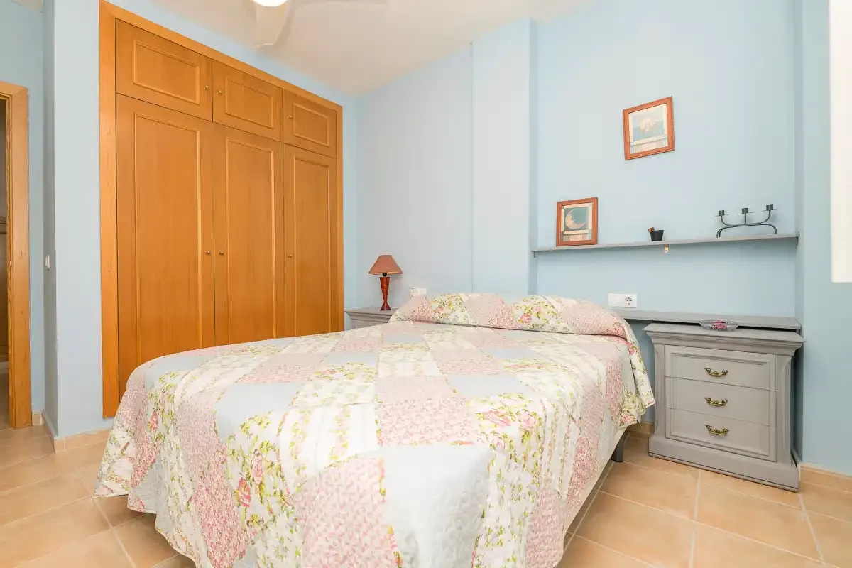 Un dormitorio con una cama y un armario empotrado de madera.