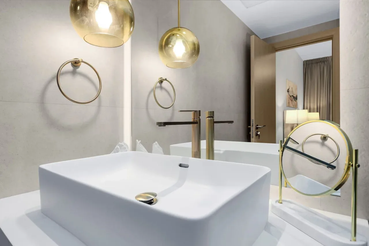 A modern bathroom with a white freestanding bathtub and brass fixtures.