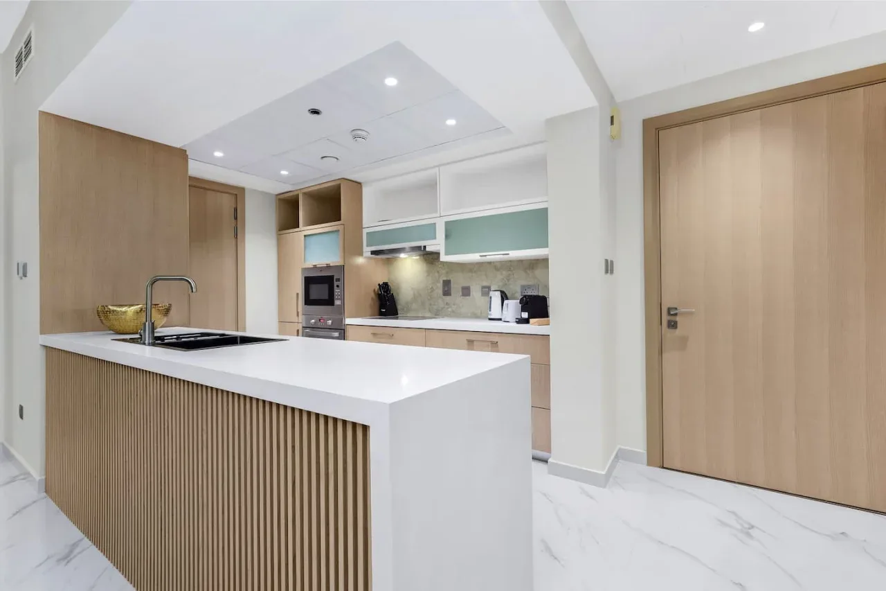 A bright modern kitchen with a white island and built-in appliances.