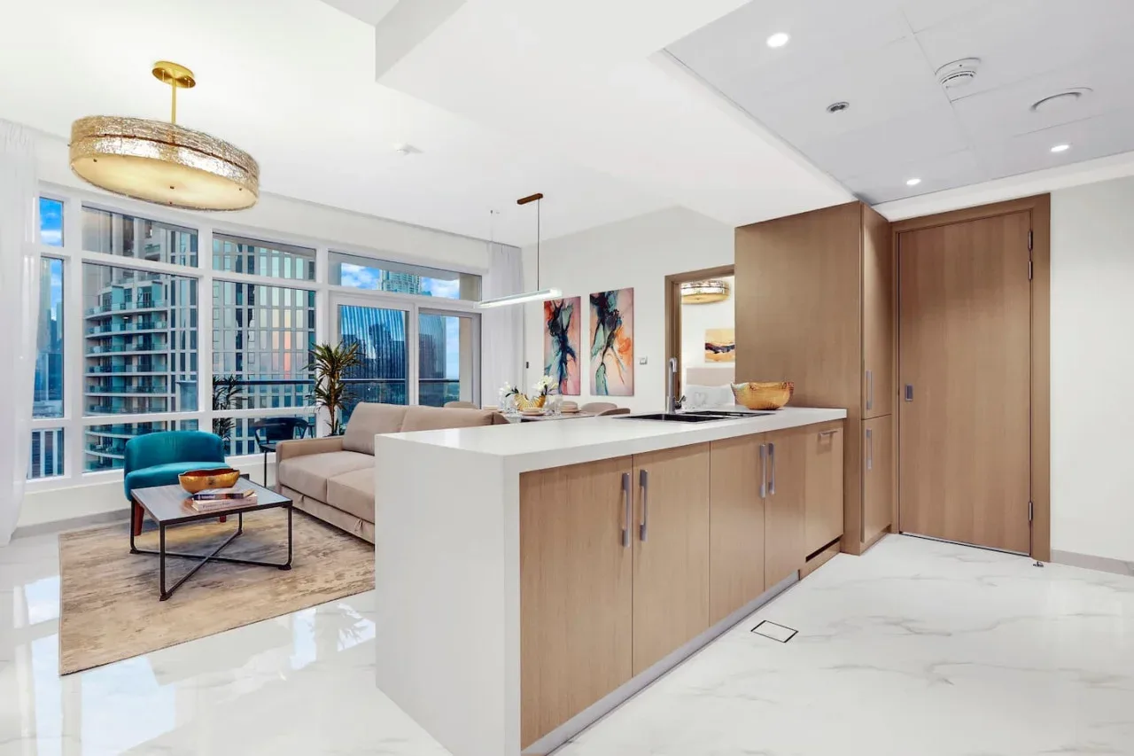 A bright open-plan living area with a large kitchen island and floor-to-ceiling windows.