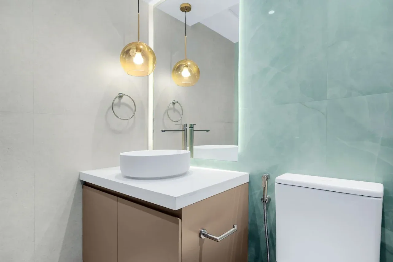 A bathroom vanity with a round basin, mirror, and toilet.