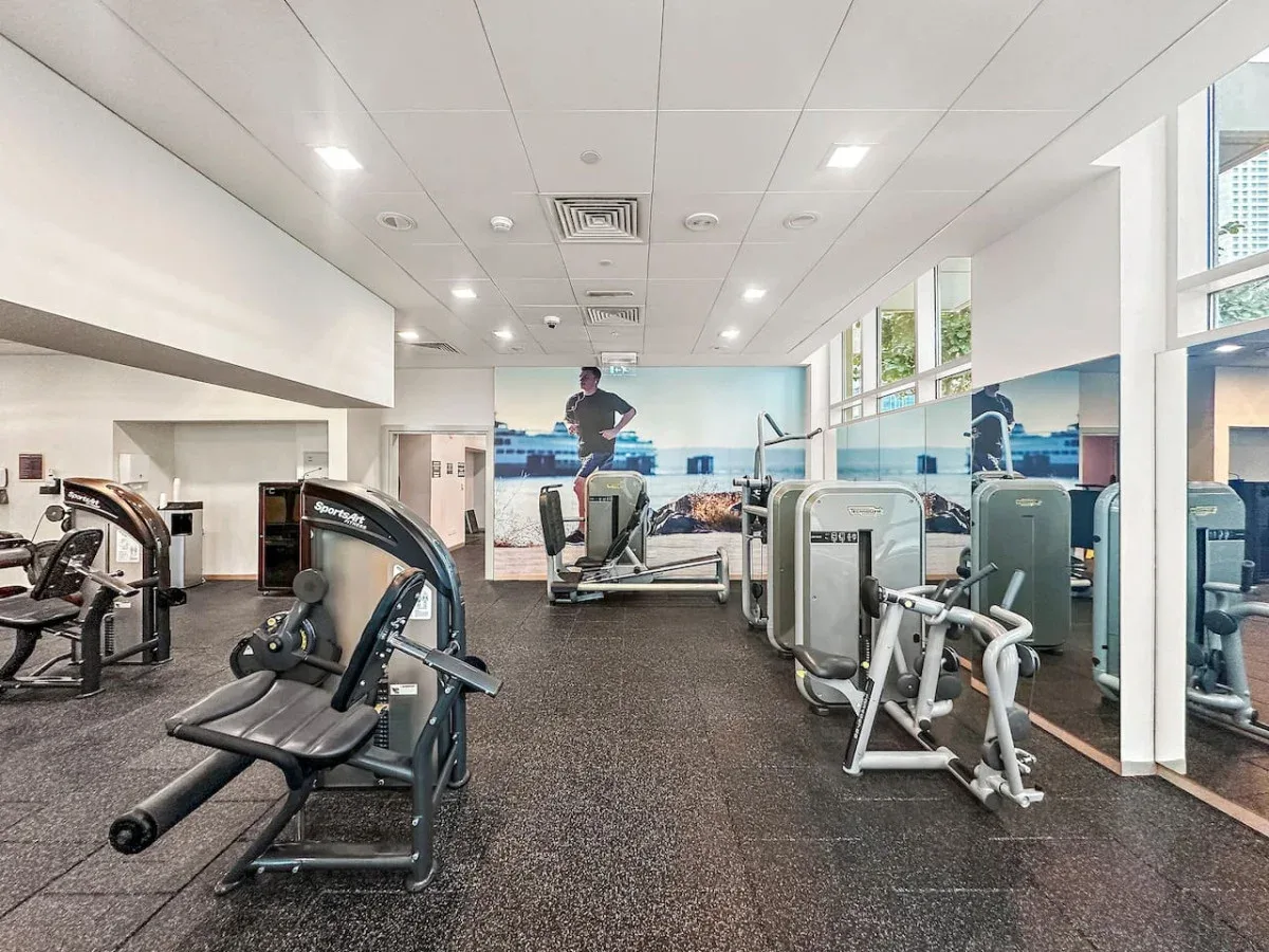 A gym with exercise machines arranged across a spacious workout area.