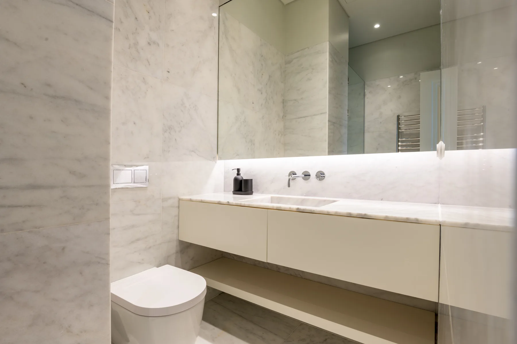 Un baño moderno con un amplio lavabo y un espejo de pared.