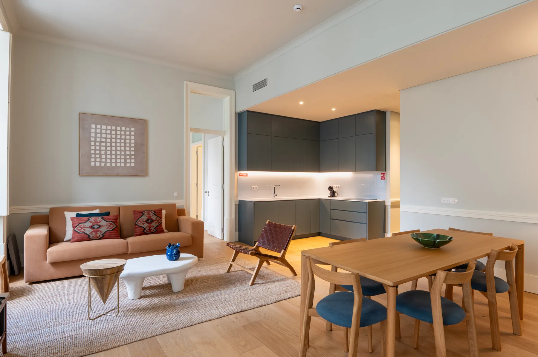 Una sala-comedor diáfana con una cocina compacta.