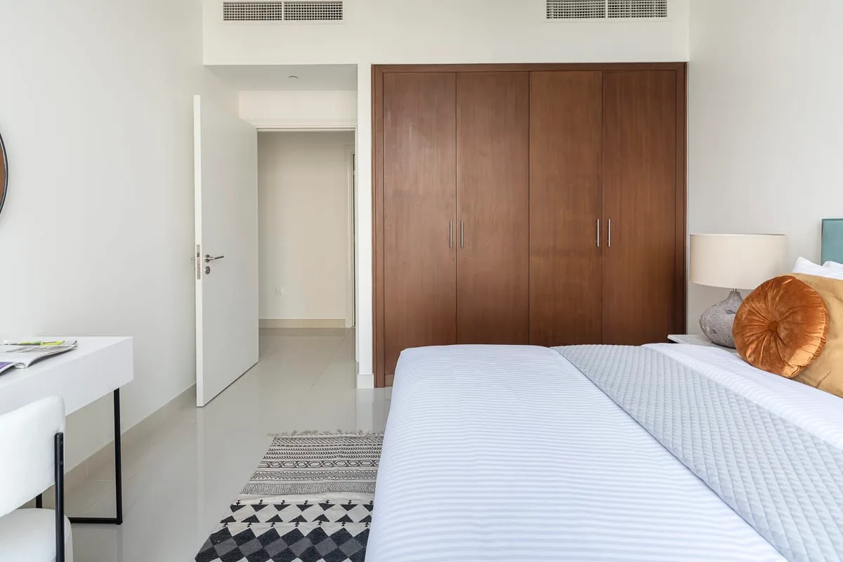 Un dormitorio con camas individuales y un gran armario de madera.
