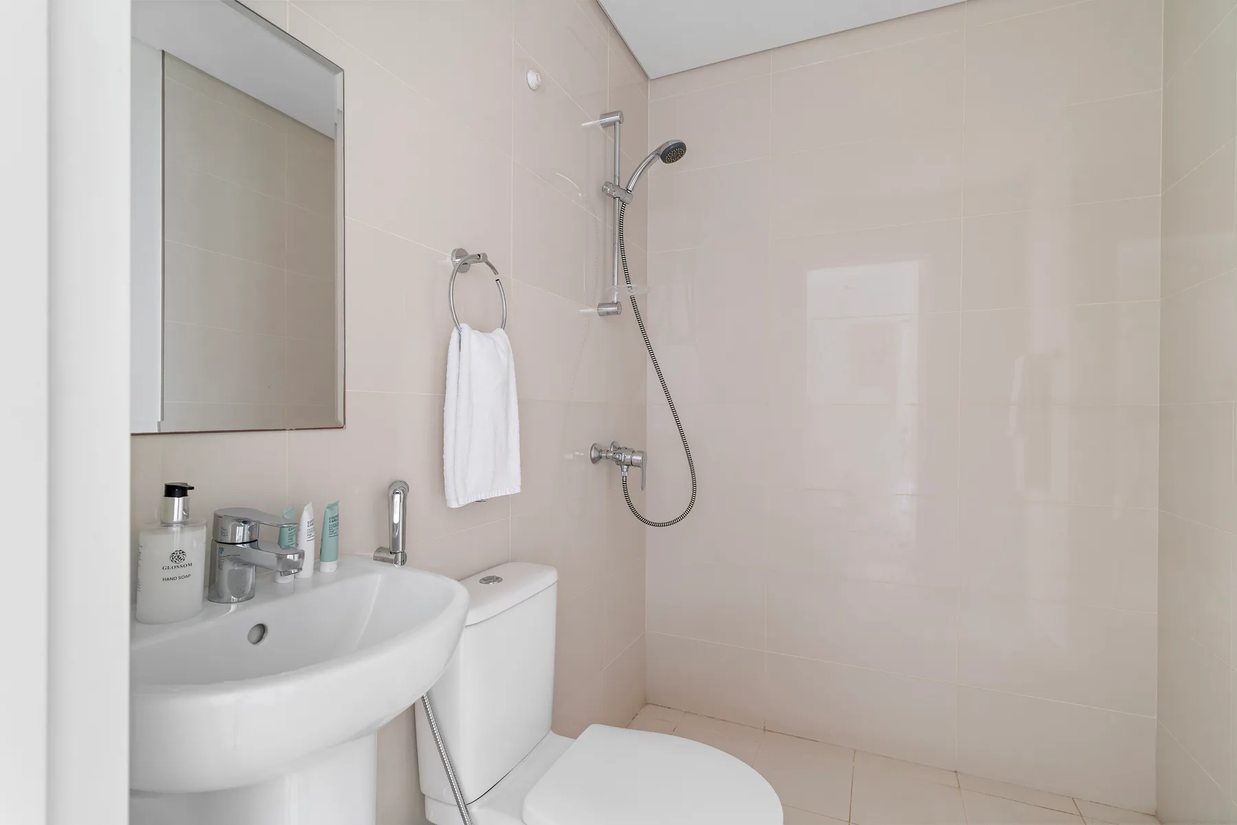 Un baño con lavabo, espejo y ducha.