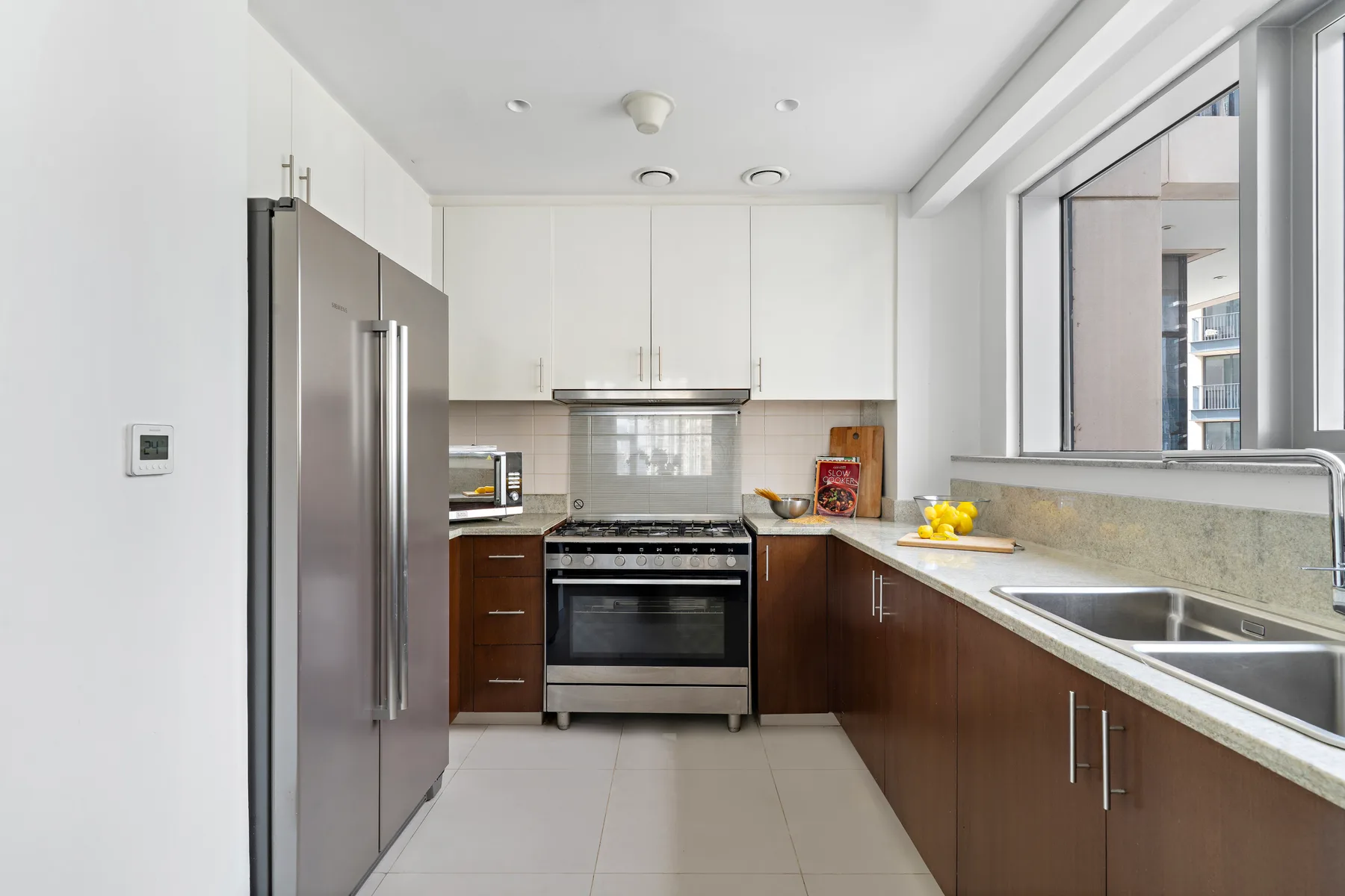 Una cocina moderna con electrodomésticos de acero inoxidable y gabinetes de madera oscura.