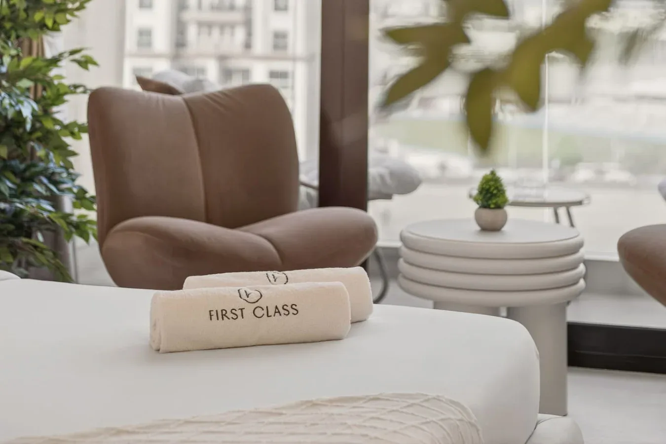A bright sitting area with a cushioned chair beside a round side table.