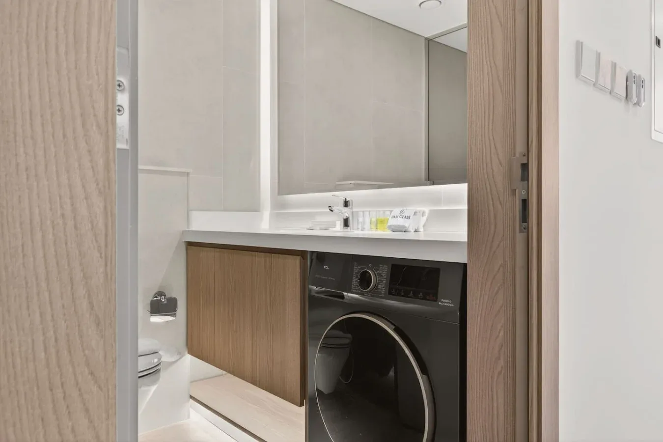 A bathroom vanity with a front-loading washing machine beneath the counter.