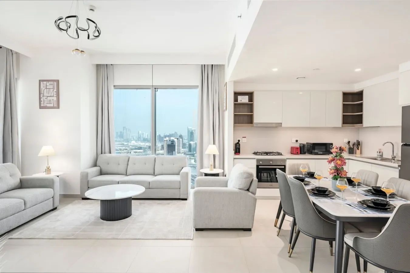 Una luminosa sala de estar y comedor se abre a la cocina, con grandes ventanas hacia la ciudad.