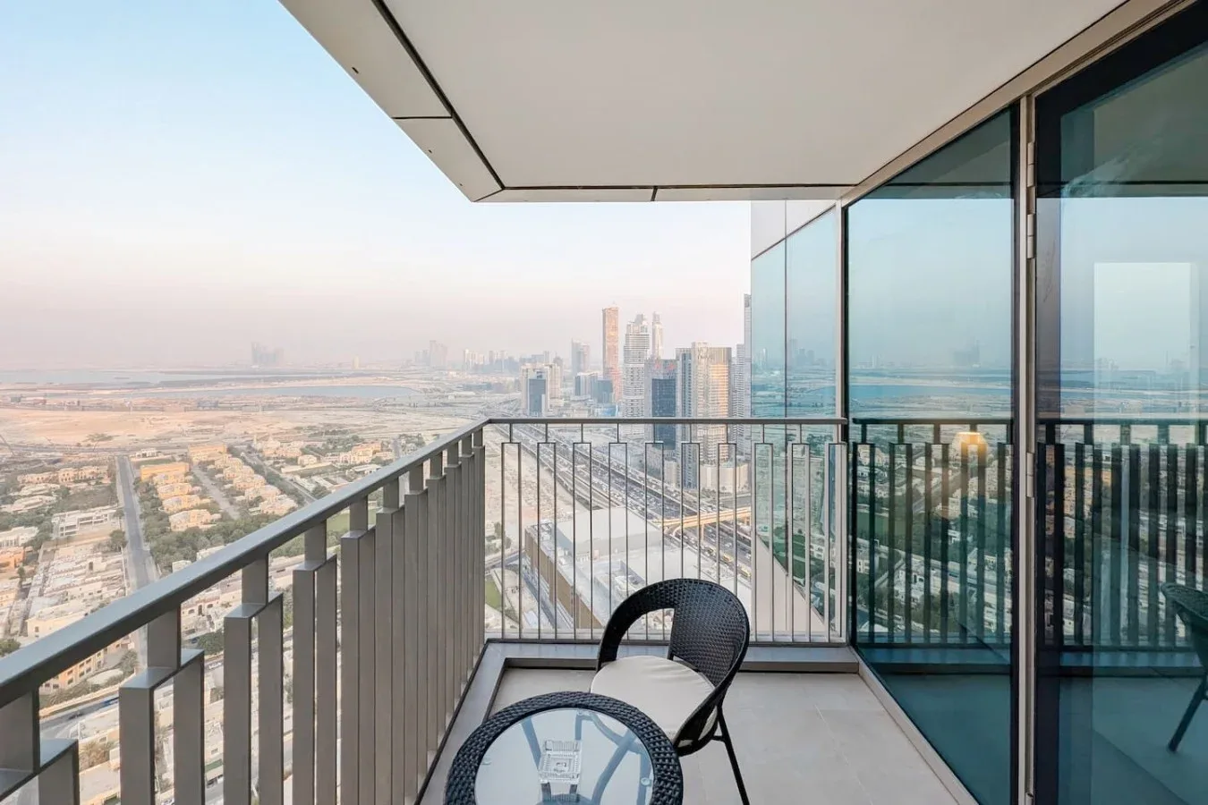 Un balcón con barandillas de vidrio y asientos tiene vistas al horizonte de la ciudad.