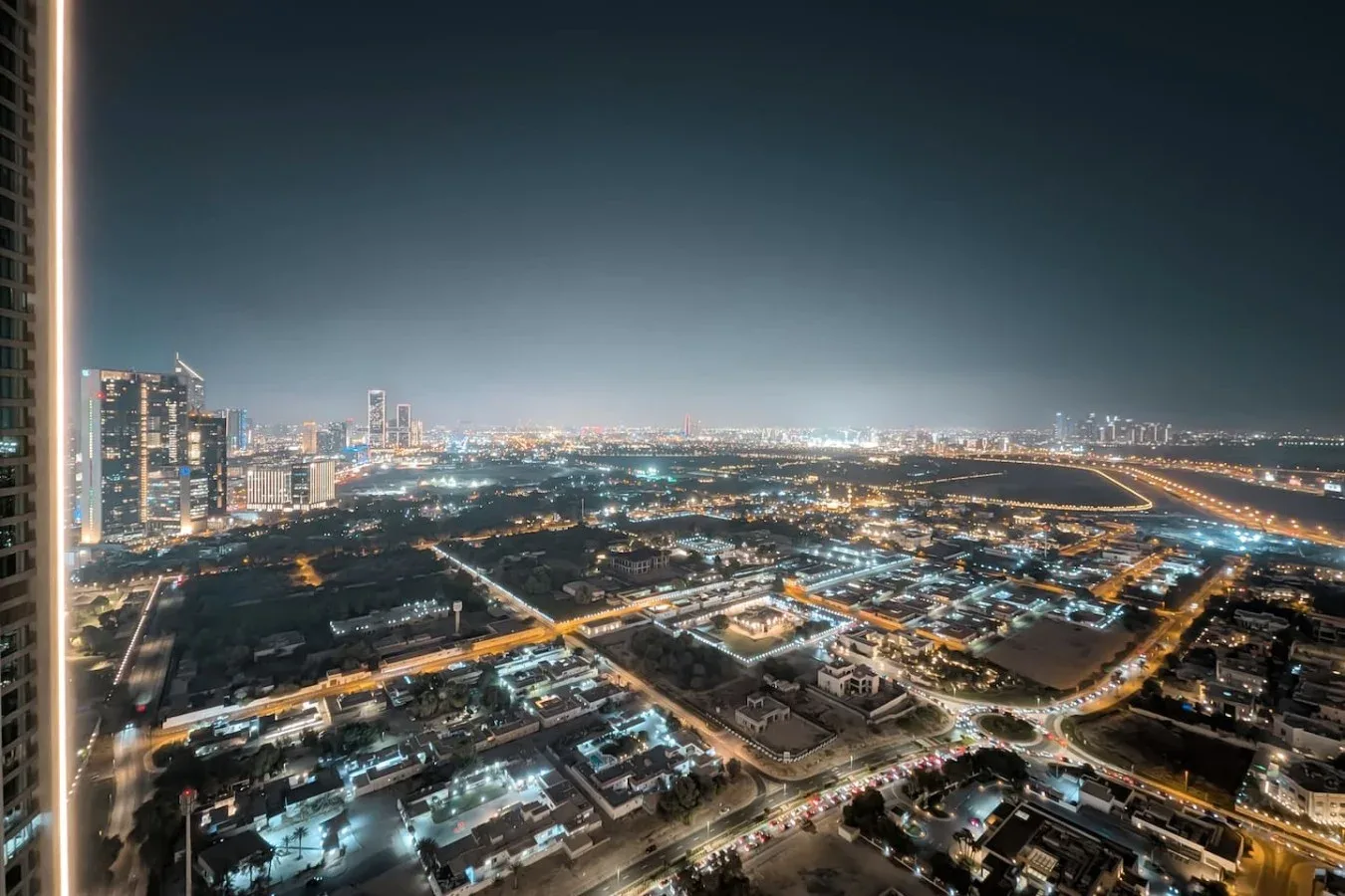 Un horizonte urbano nocturno con calles y edificios iluminados.