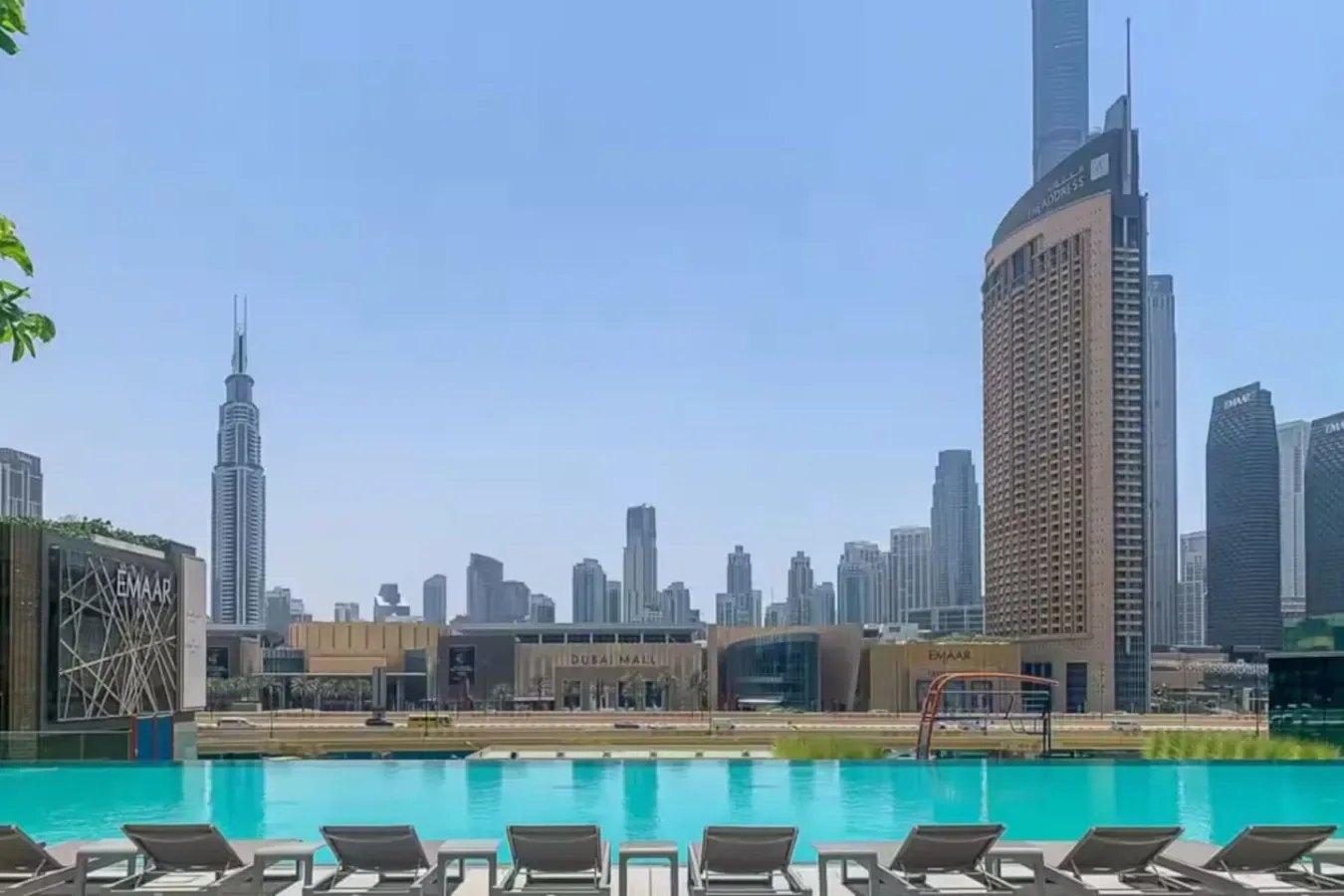 Una piscina en la azotea ofrece vistas al horizonte urbano, con asientos junto al agua.