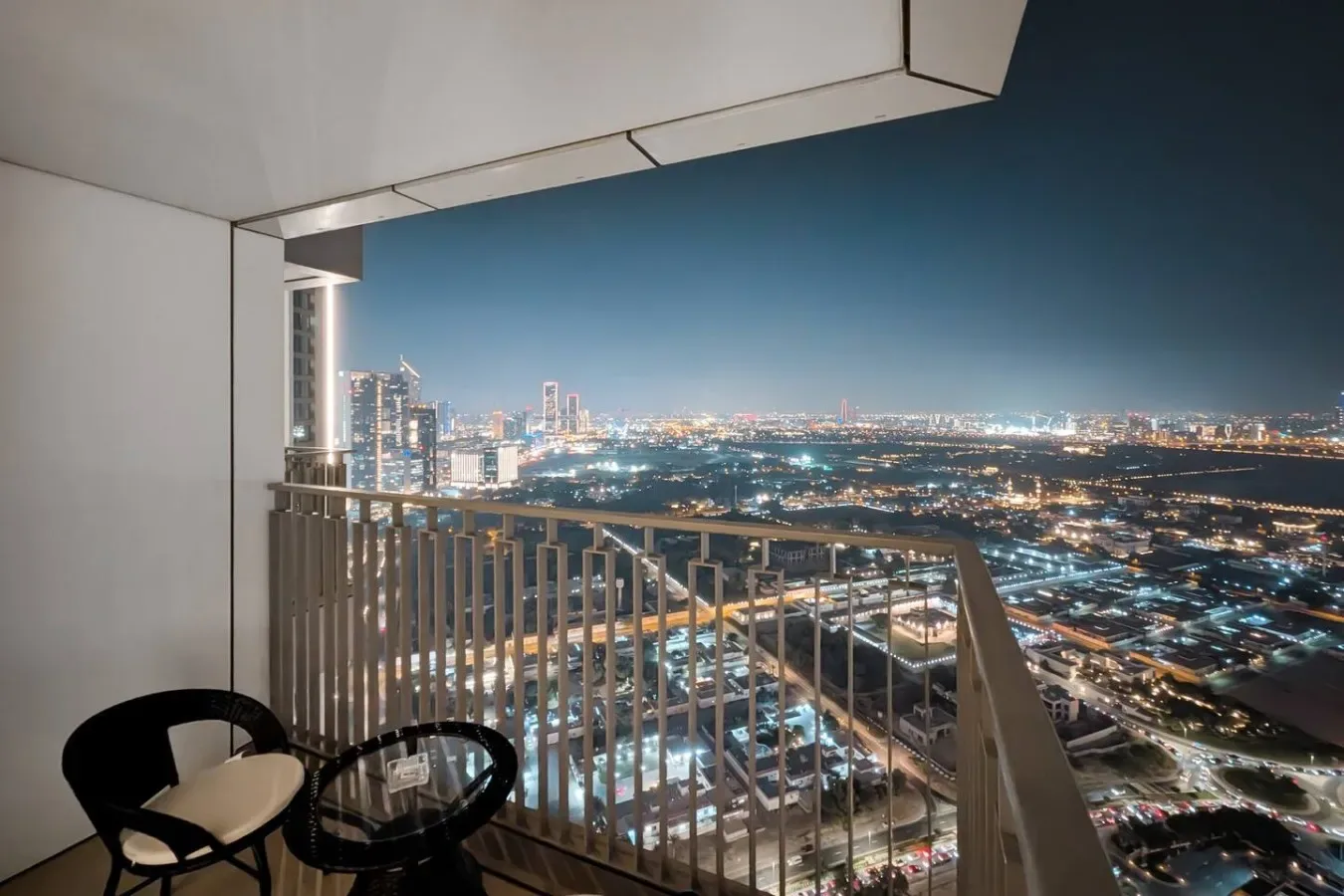 Un balcón ofrece vistas de un horizonte urbano iluminado por la noche.