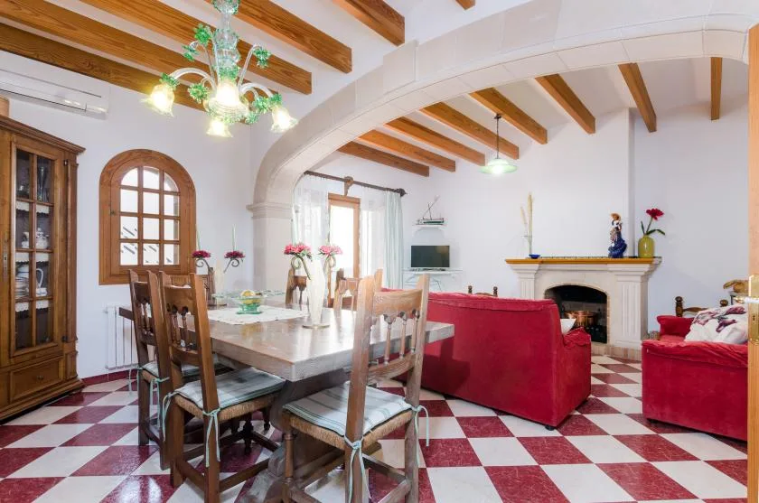 A dining and living room with a wooden table and seating near a fireplace.