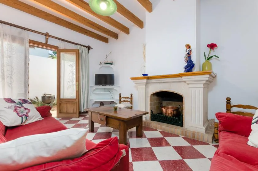 A living room with red seating, a fireplace, and a red-and-white tiled floor.