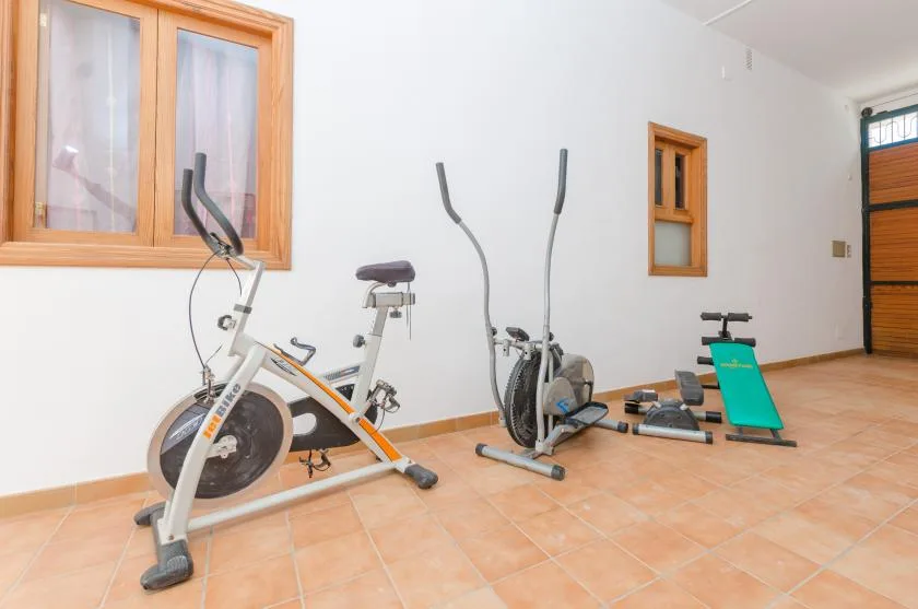 A home exercise area with stationary bikes and other workout equipment.