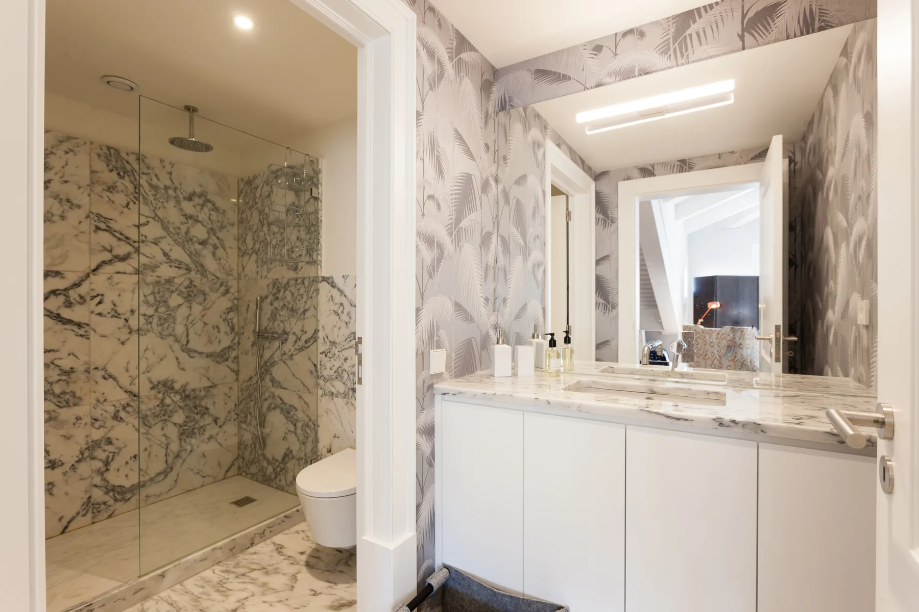 Un baño con un lavabo amplio y una ducha con mampara de vidrio.