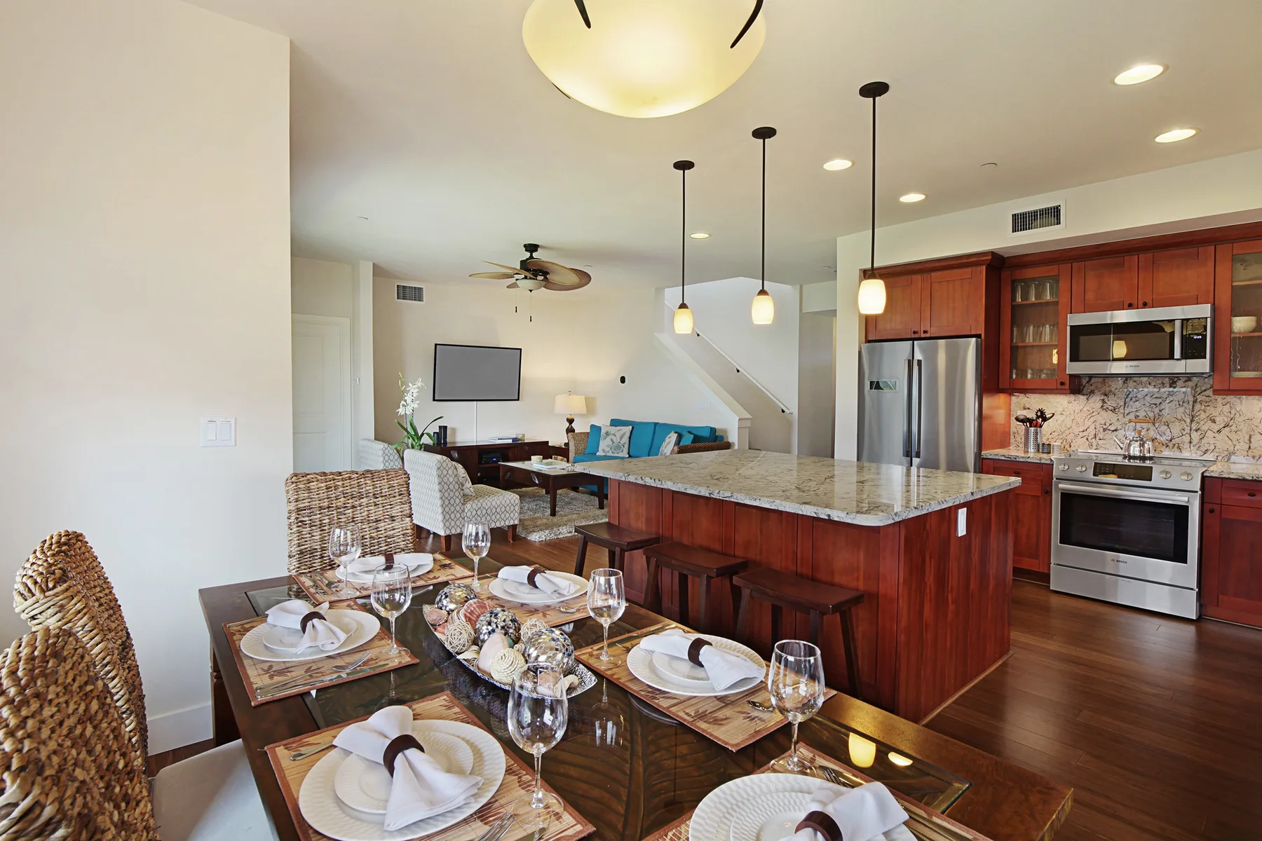 Una cocina y comedor de planta abierta con barra y sala de estar al fondo.