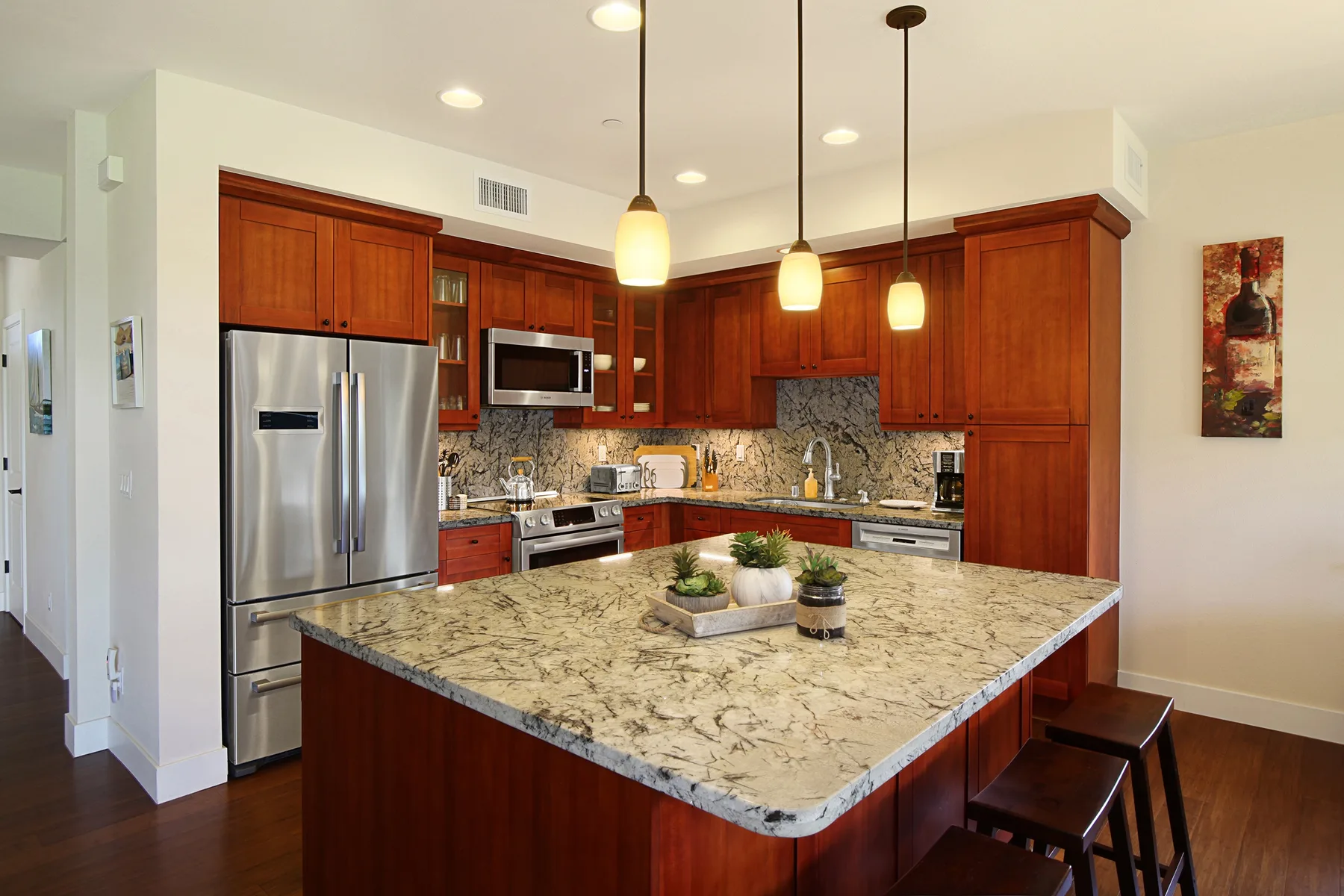 Una cocina amplia con gabinetes de madera y una gran isla con encimera de piedra.