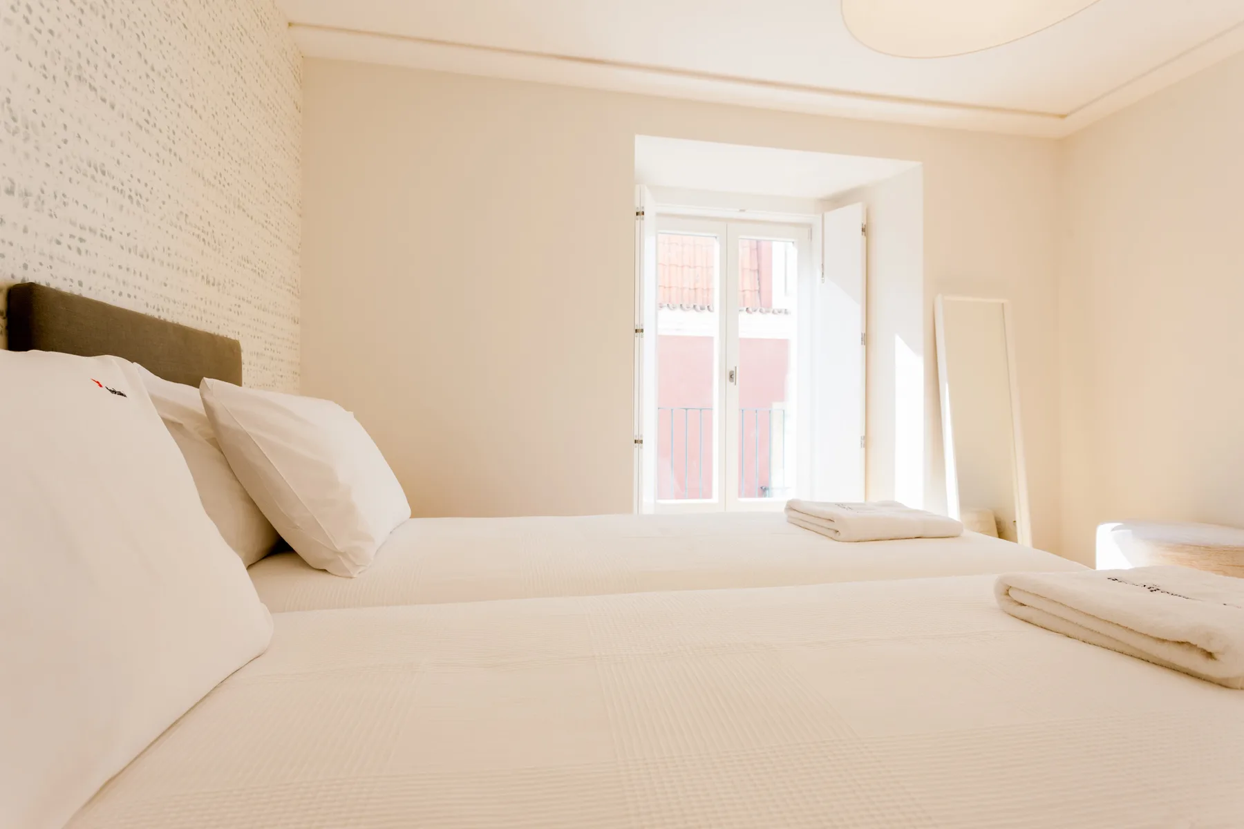 A bright bedroom with a bed and a window.
