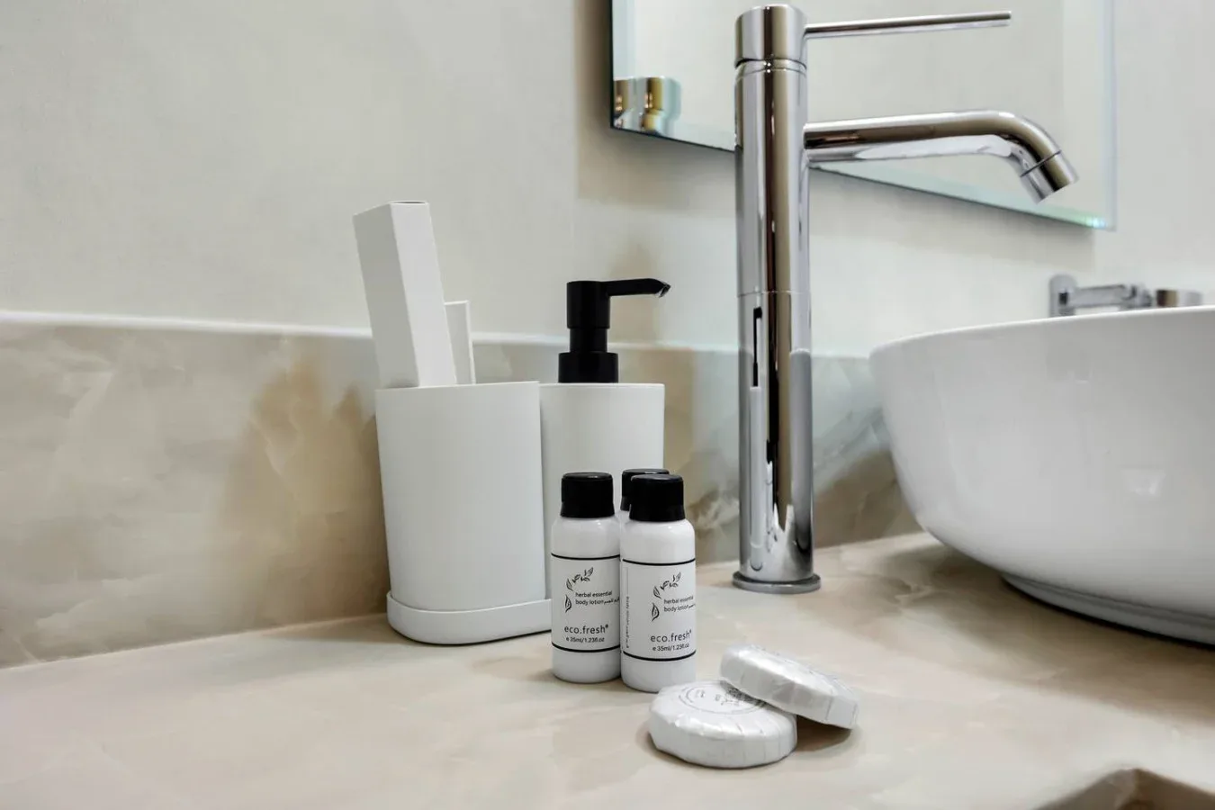 A bathroom vanity with a vessel sink, faucet, and toiletries on the counter.