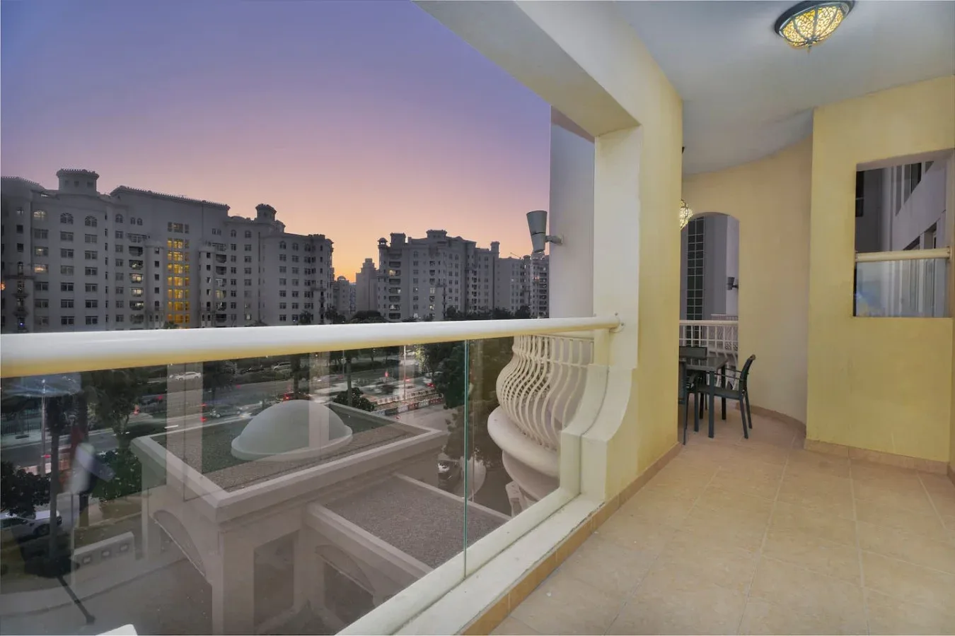 A balcony overlooks nearby apartment buildings at dusk.