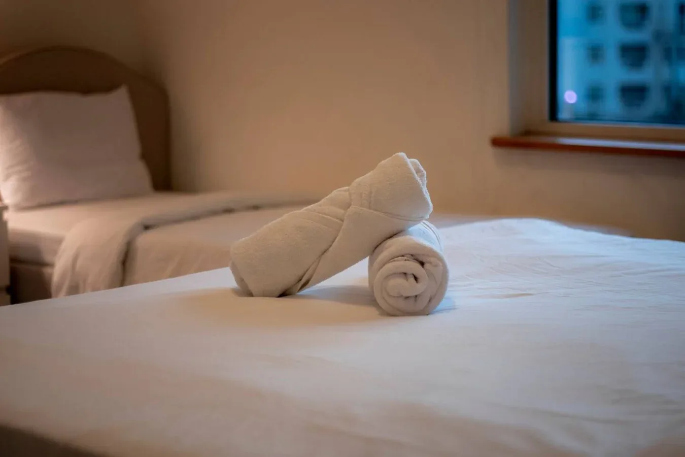 A bedroom with folded towels placed on the bed.