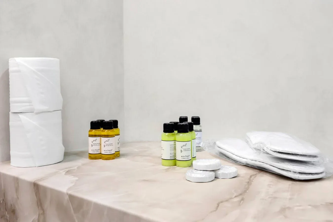 Bathroom toiletries and neatly folded towels sit on a countertop.