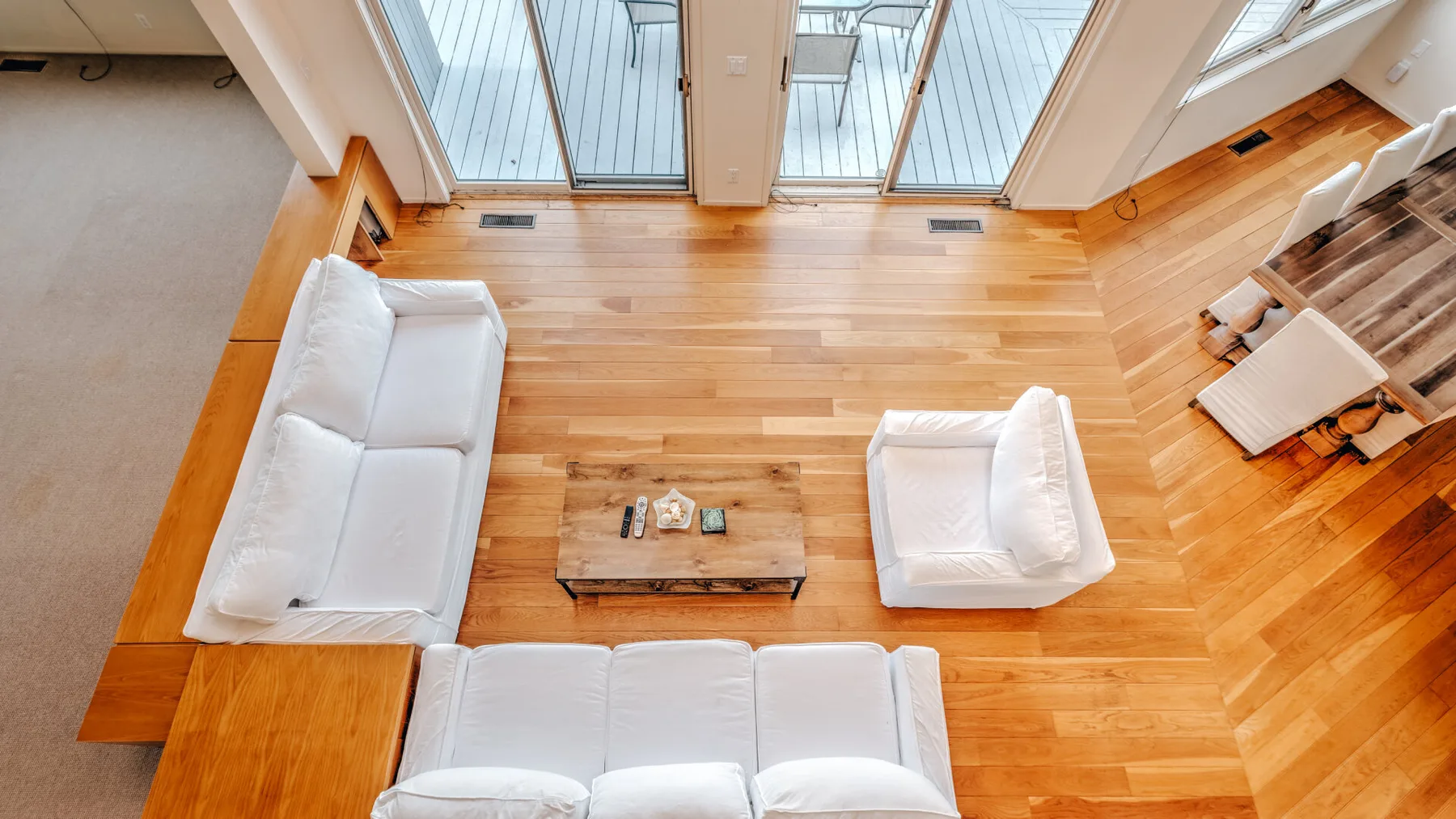 Una sala luminosa con asientos blancos alrededor de una mesa baja de madera.