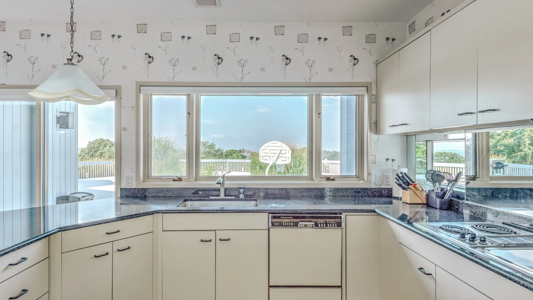Una cocina luminosa con gabinetes blancos, encimeras y una ventana amplia.