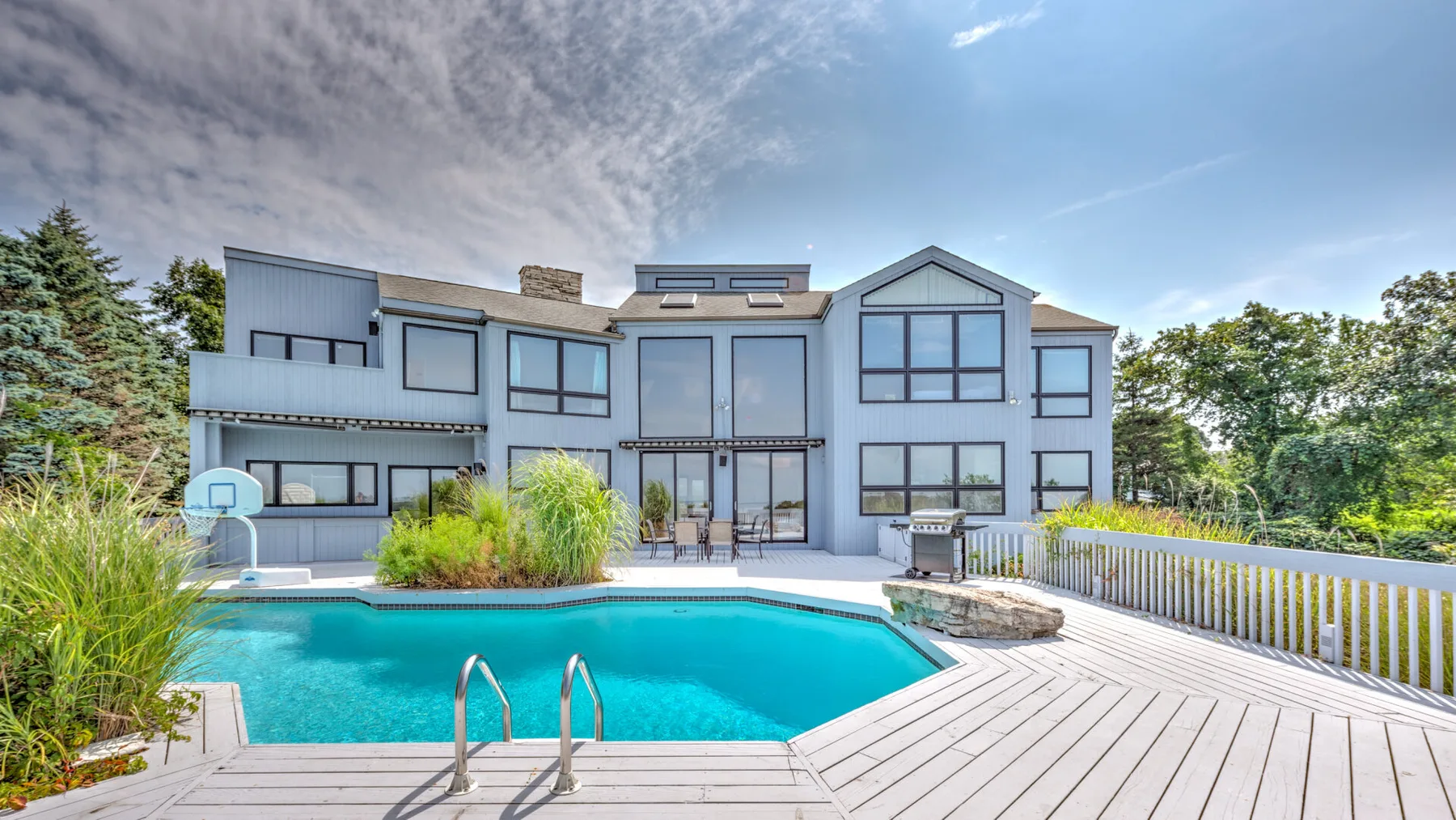 Una casa moderna da a una piscina y una amplia terraza.