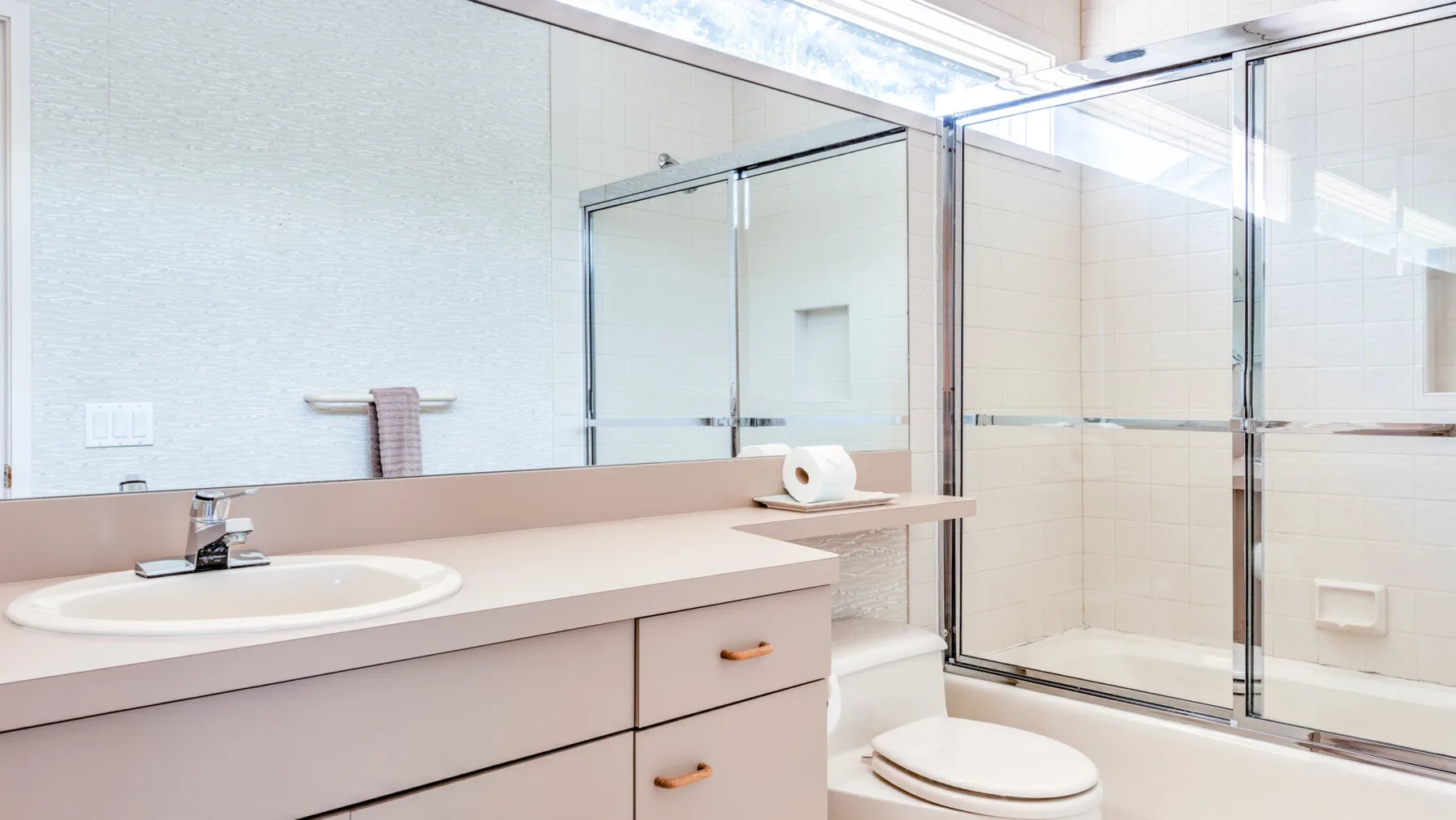 Un baño luminoso con lavabo y ducha de vidrio.