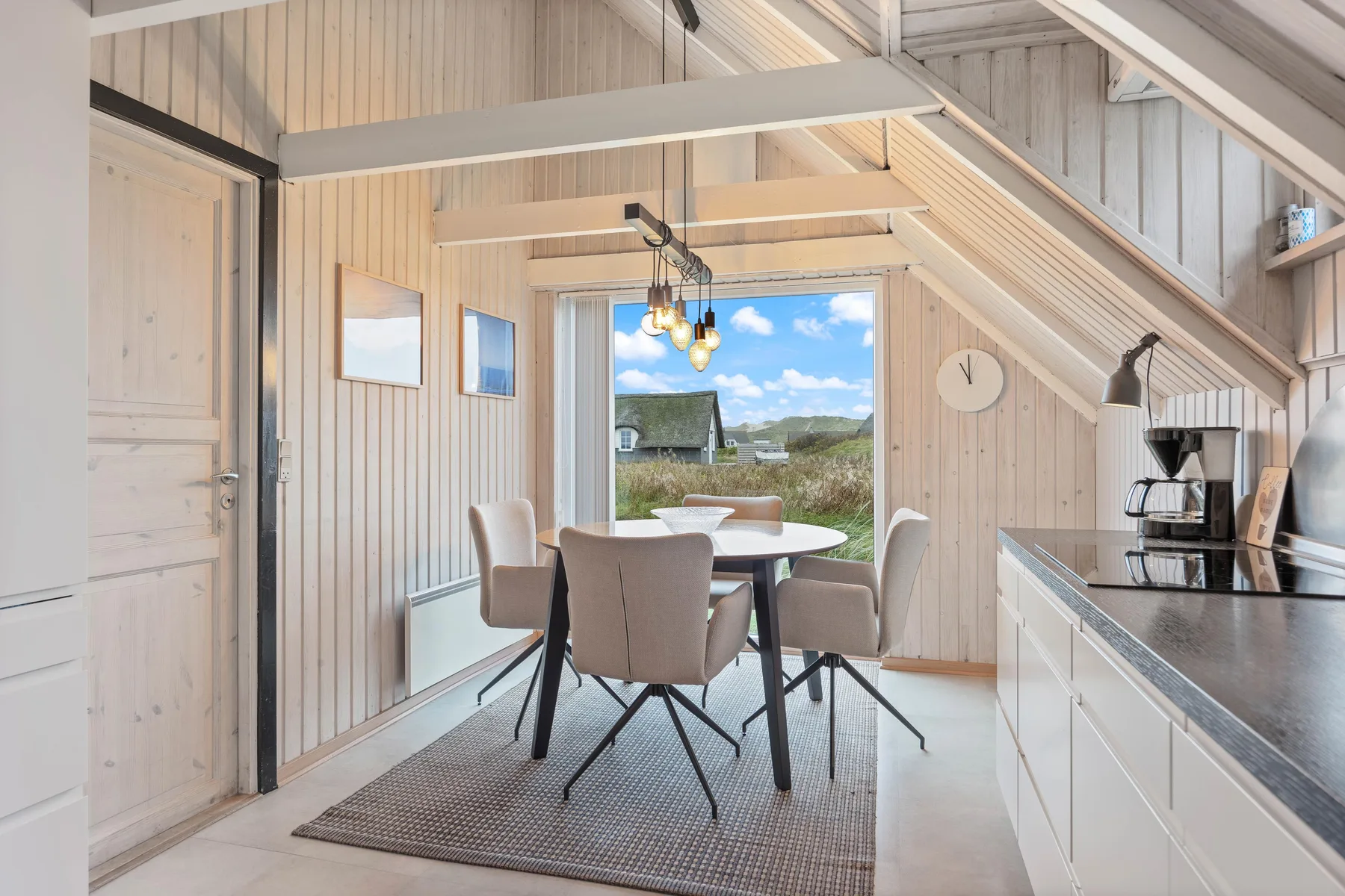A bright dining area with a table and chairs beside the kitchen counter.