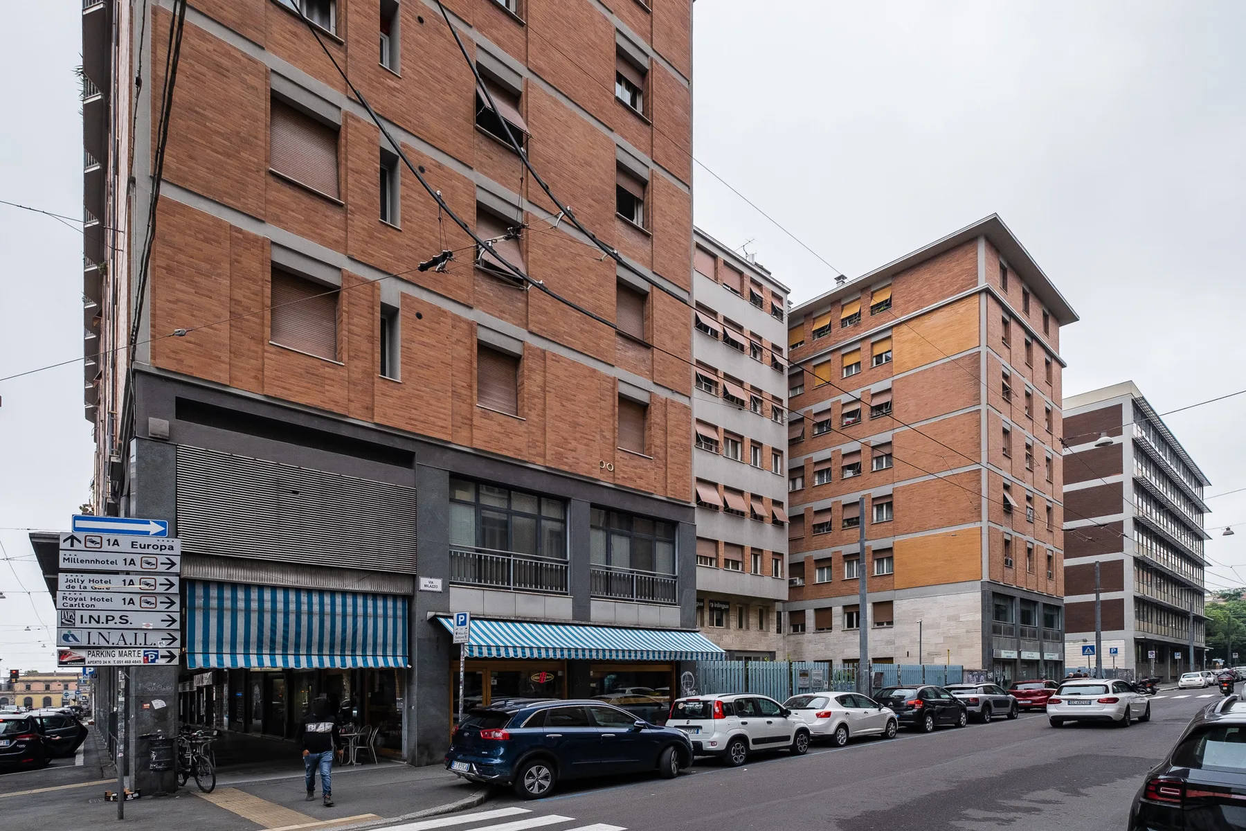 Escena urbana con edificios de ladrillo y coches estacionados.