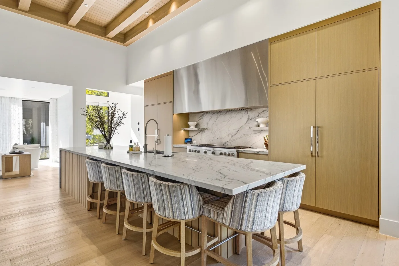 A bright kitchen with a long island and several bar stools.