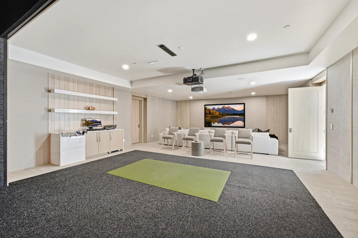 A bright lounge area with a large open carpeted floor and seating at the back.
