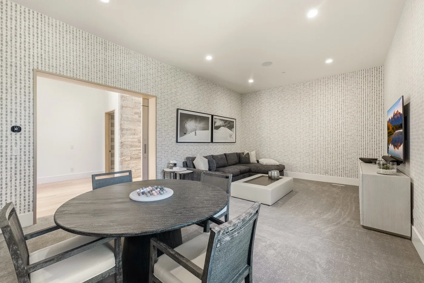 A dining area opens into a living room with a sofa and low table.