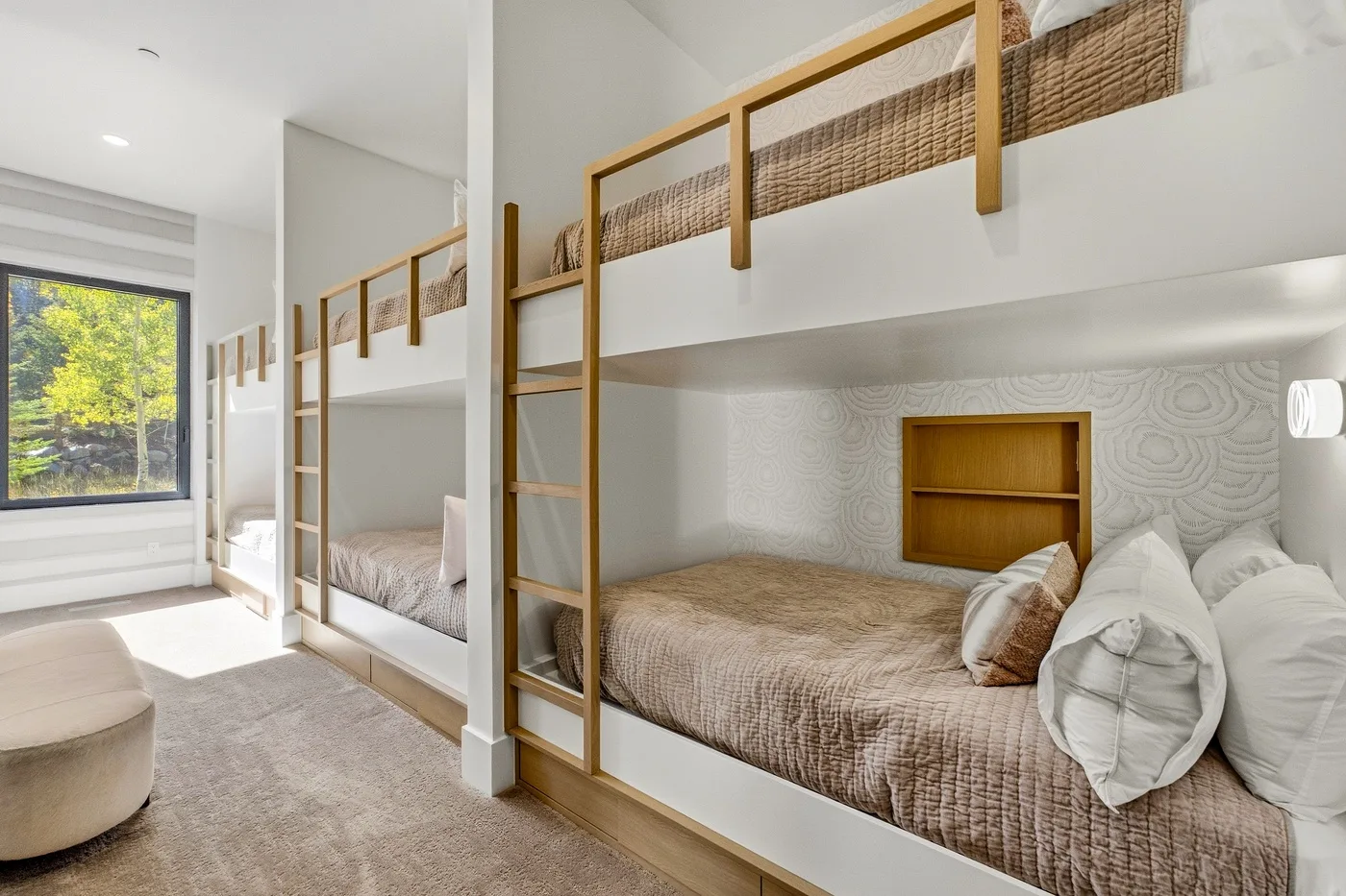 A bright bedroom with built-in bunk beds and a large window.