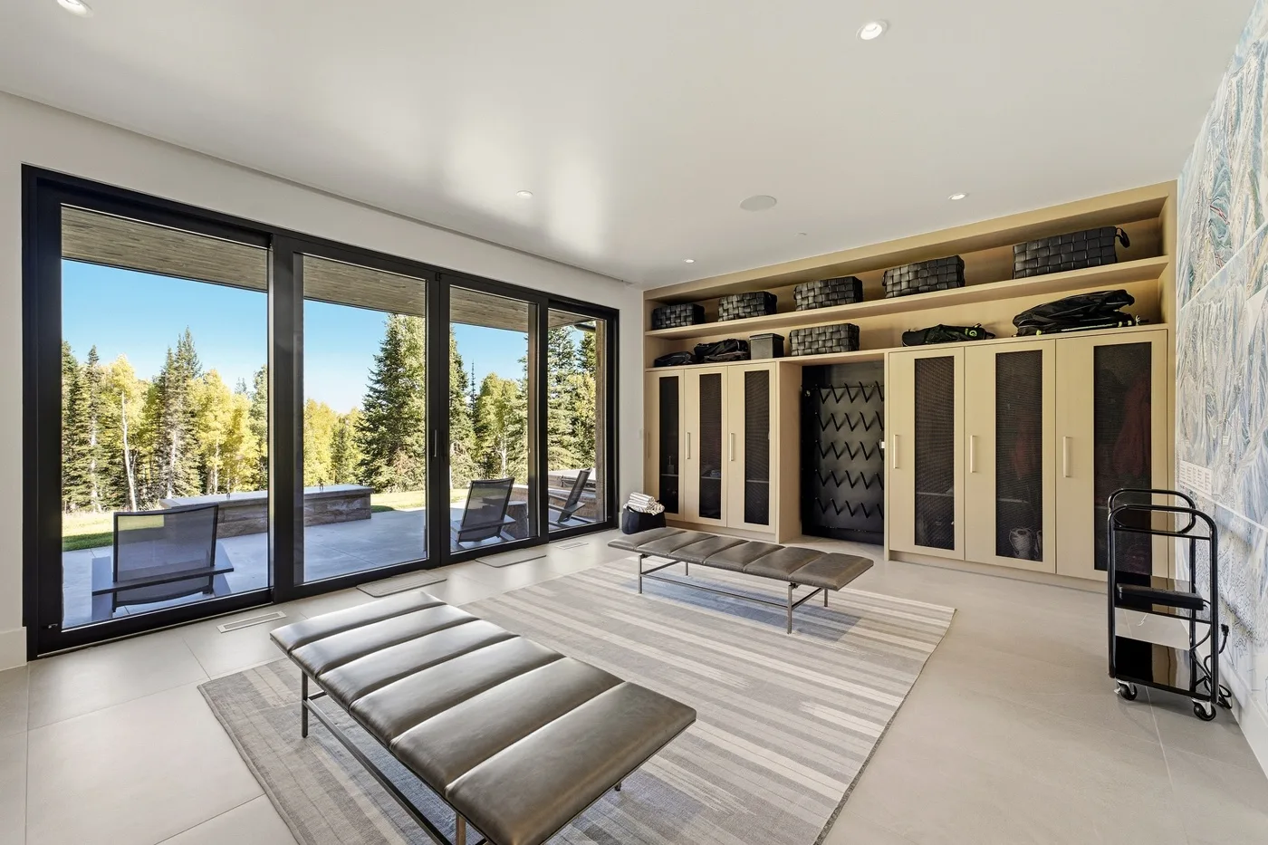 A bright lounge with large windows, low seating, and built-in storage.